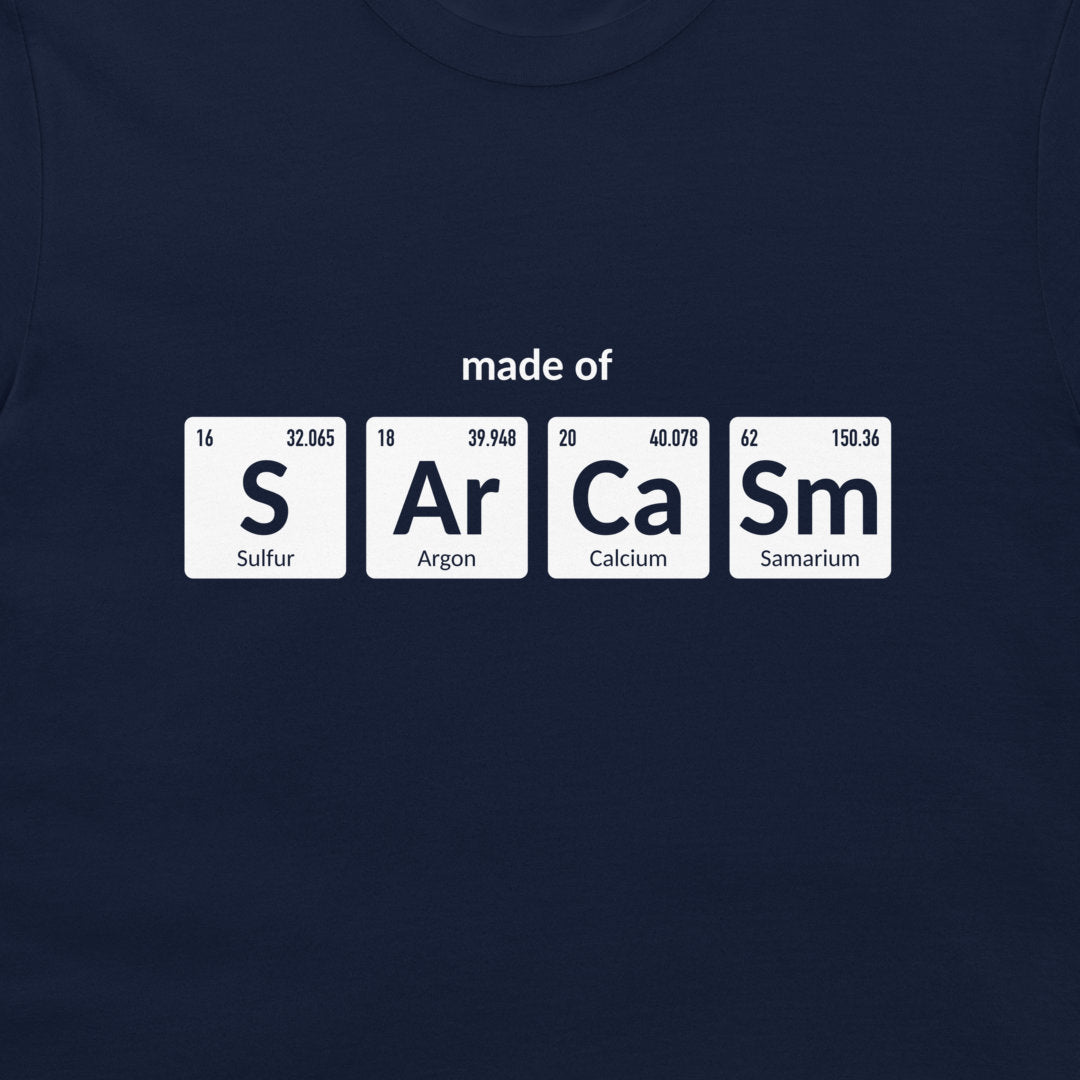 A navy blue crewneck t-shirt featuring a graphic print of four white periodic table element tiles spelling out 'made of' with 'S', 'Ar', 'Ca', and 'Sm' and their respective symbols and chemical names.