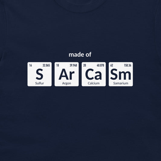 A navy blue crewneck t-shirt featuring a graphic print of four white periodic table element tiles spelling out 'made of' with 'S', 'Ar', 'Ca', and 'Sm' and their respective symbols and chemical names.