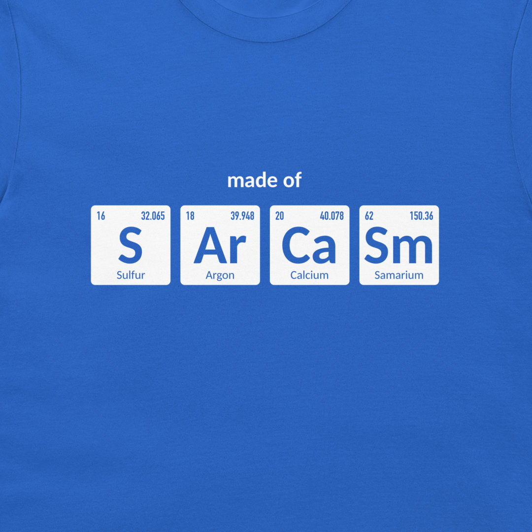 A royal blue crewneck t-shirt featuring a graphic print of four white periodic table element tiles spelling out 'made of' with 'S', 'Ar', 'Ca', and 'Sm' and their respective symbols and chemical names.