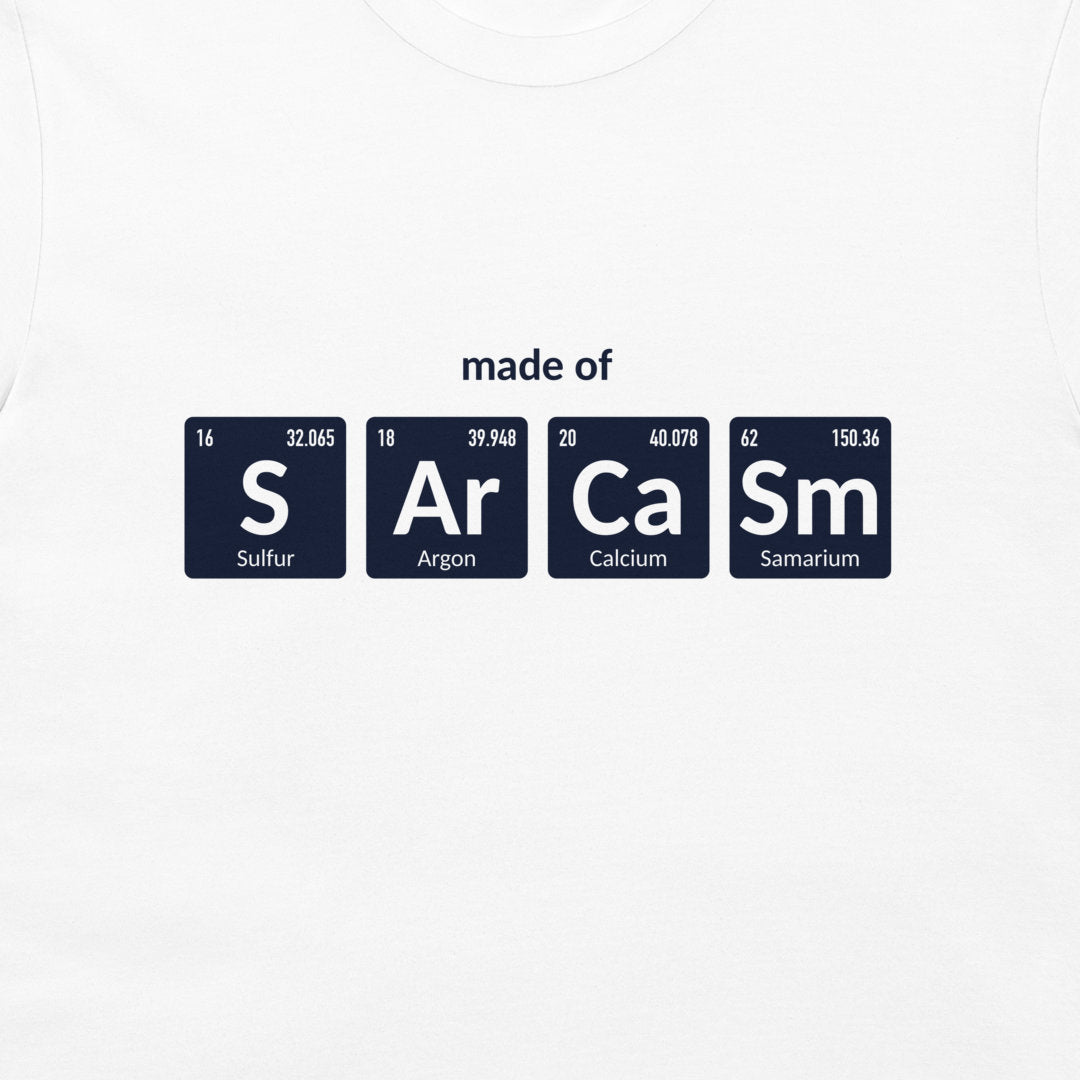 A white crewneck t-shirt featuring a graphic print of four dark blue periodic table element tiles spelling out 'made of' with 'S', 'Ar', 'Ca', and 'Sm' and their respective symbols and chemical names.