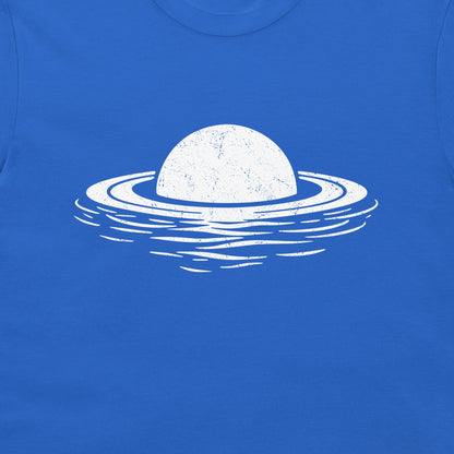 A close-up of a bright blue t-shirt featuring a distressed white graphic of a planet with rings floating on water.