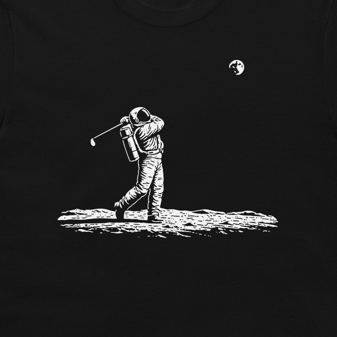 A black crewneck t-shirt featuring a white graphic print of an astronaut golfing on the moon, with a small moon and planet illustration in the upper right.