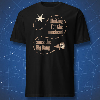 Black t-shirt with minimalist science humor design reading “Waiting for the weekend since the Big Bang,” featuring a dashed cosmic path from a starburst to a lying sloth.