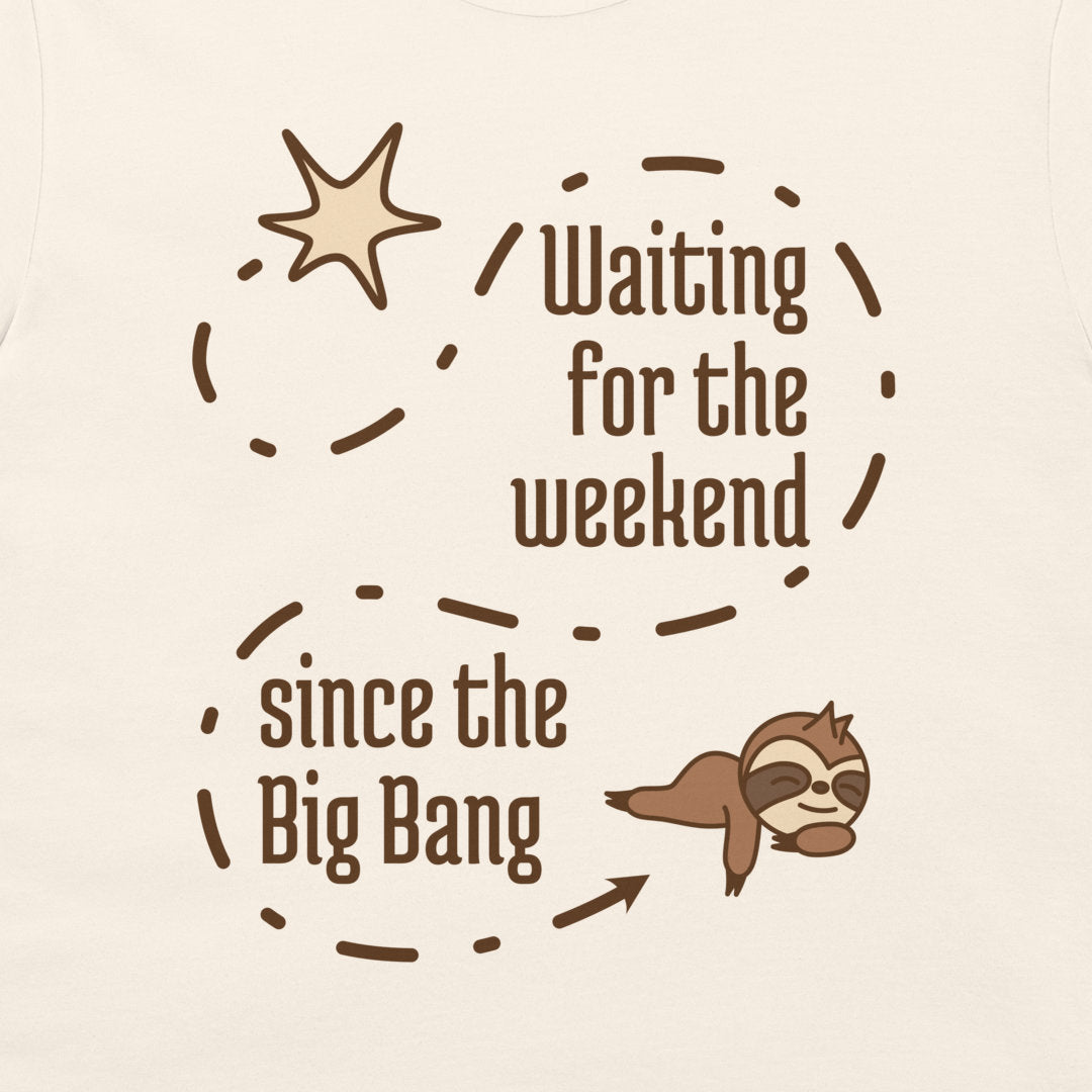 A close-up of a light cream-colored garment featuring a brown graphic print. The design includes the text 'Waiting for the weekend since the Big Bang' arranged in a circular dashed path, accompanied by a explosion illustration at the top and a cartoon sloth at the bottom right.
