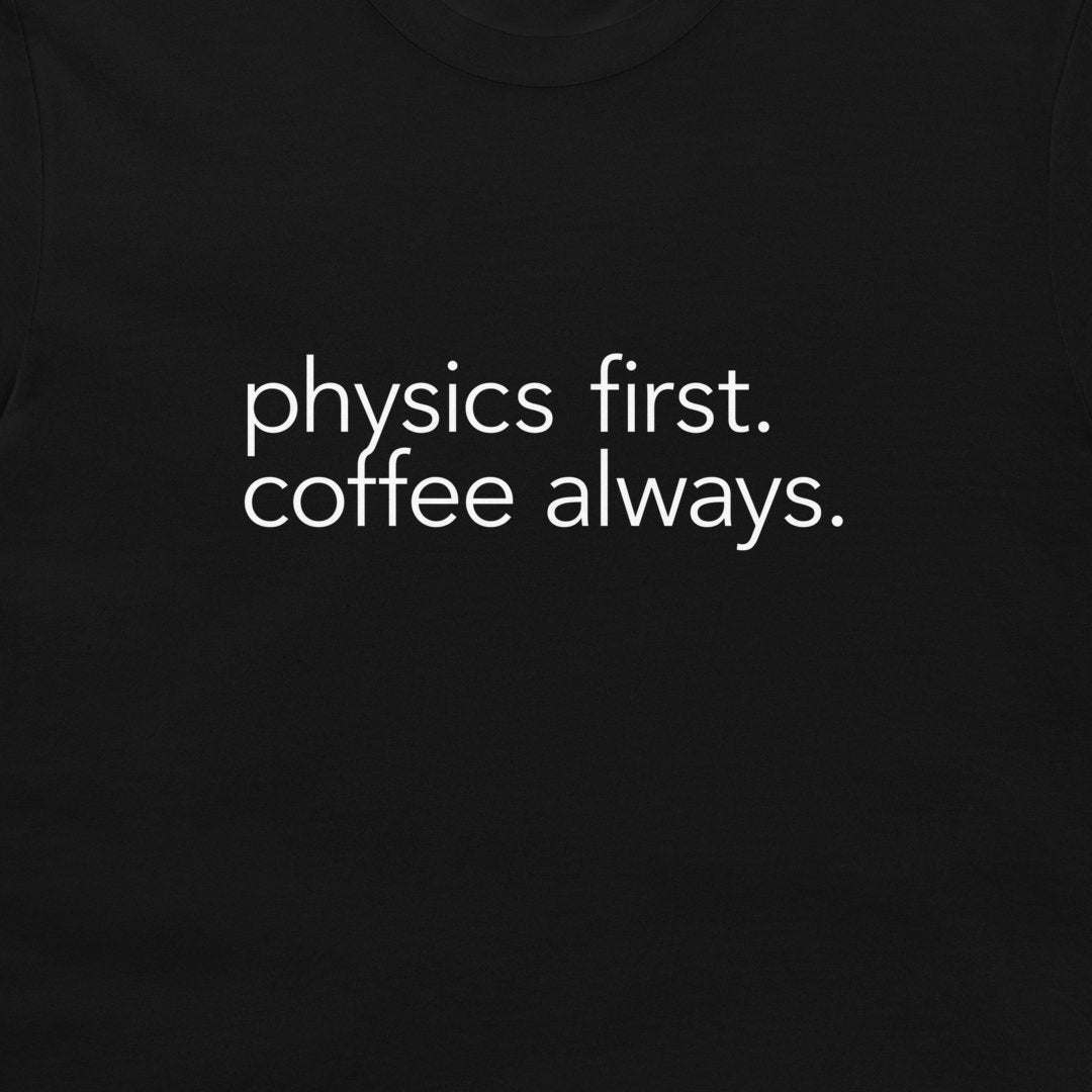 A close-up of a black t-shirt featuring the phrase 'physics first. 