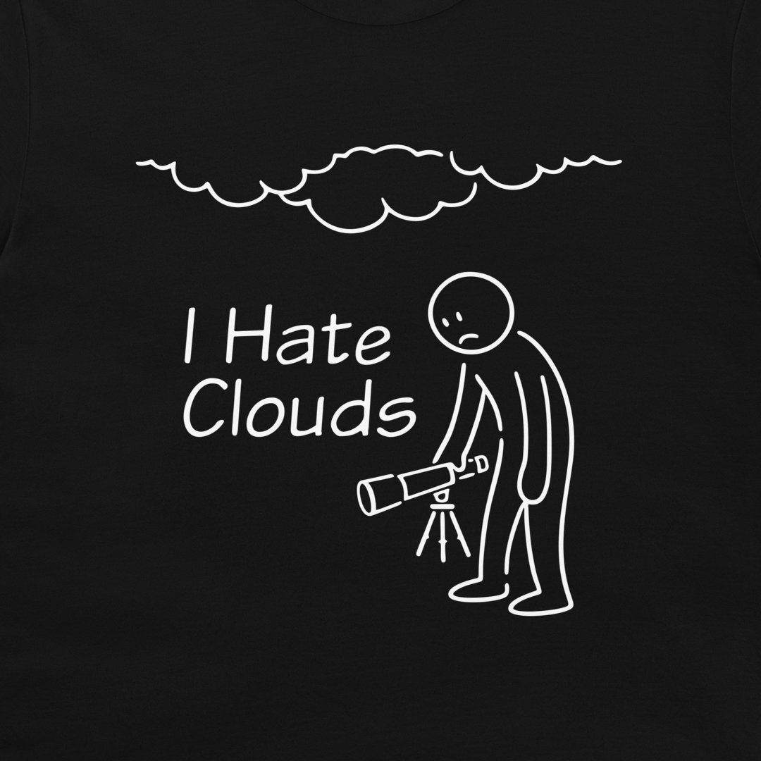 A close-up of a black  t-shirt, featuring a white graphic print. The design shows a stick figure holding a telescope under a cloud, with the text 'I Hate Clouds'.