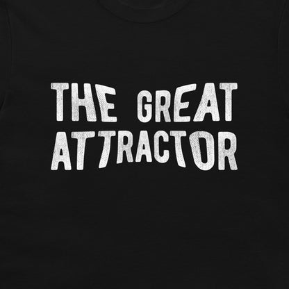 A close-up of a black t-shirt featuring the phrase 'THE GREAT ATTRACTOR' printed in a distressed white textured font across the chest.