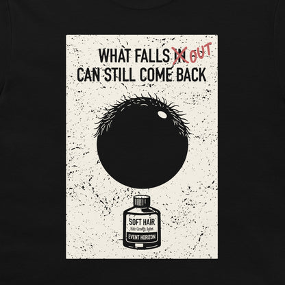 A black crewneck t-shirt featuring a distressed white rectangular graphic print. The graphic displays the text 'WHAT FALLS IN CAN STILL COME BACK' with 'IN' crossed out in red scribble, and written 'OUT' next to it. Below there is a black circle representing a hair follicle and a black hole in the same time, and an illustration of a small bottle labeled 'SOFT HAIR'.