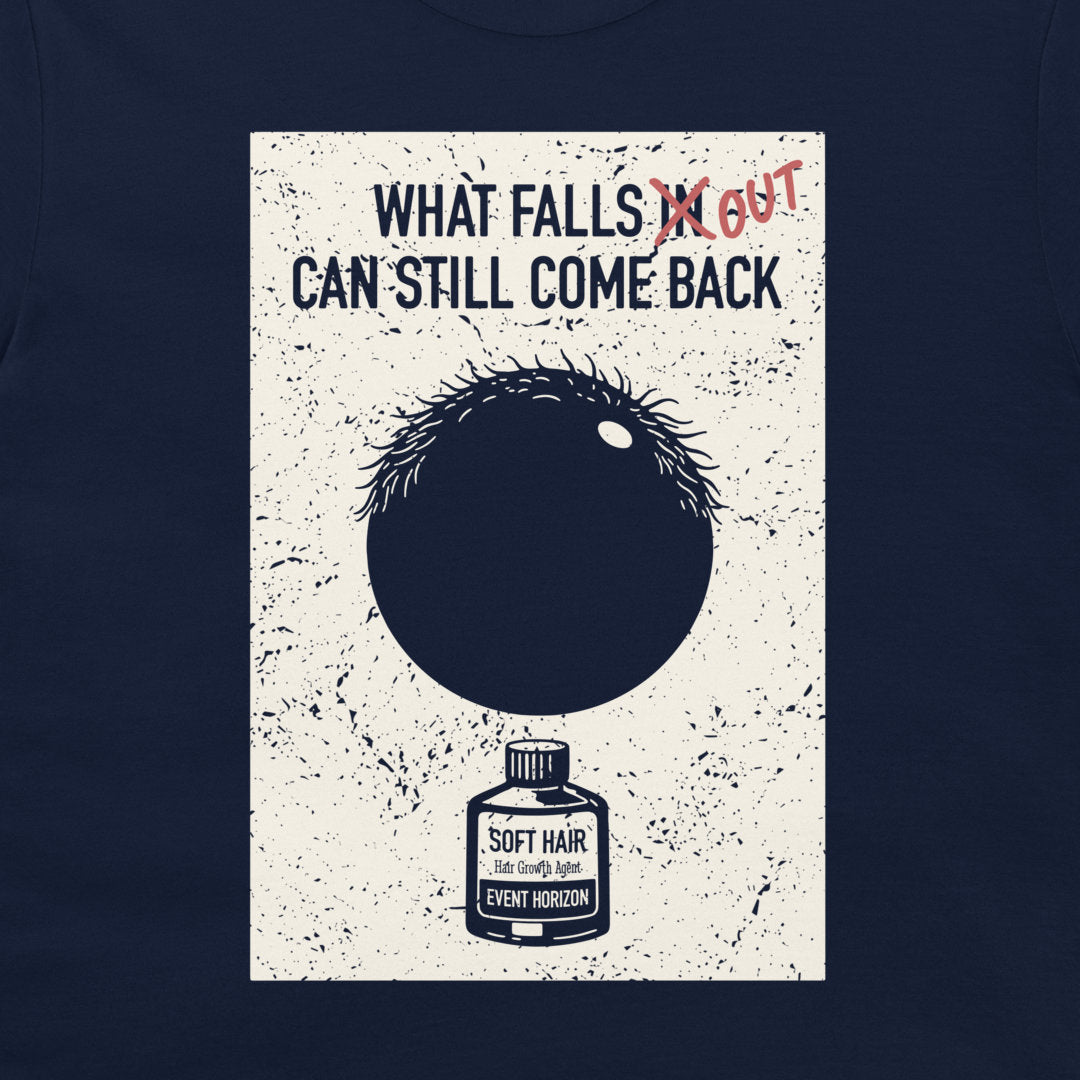 A dark navy blue t-shirt featuring a large rectangular graphic print on the front. The print has a distressed off-white background with the text 'WHAT FALLS IN CAN STILL COME BACK' above a black circle with spiky hair and a small bottle labeled 'SOFT HAIR'.