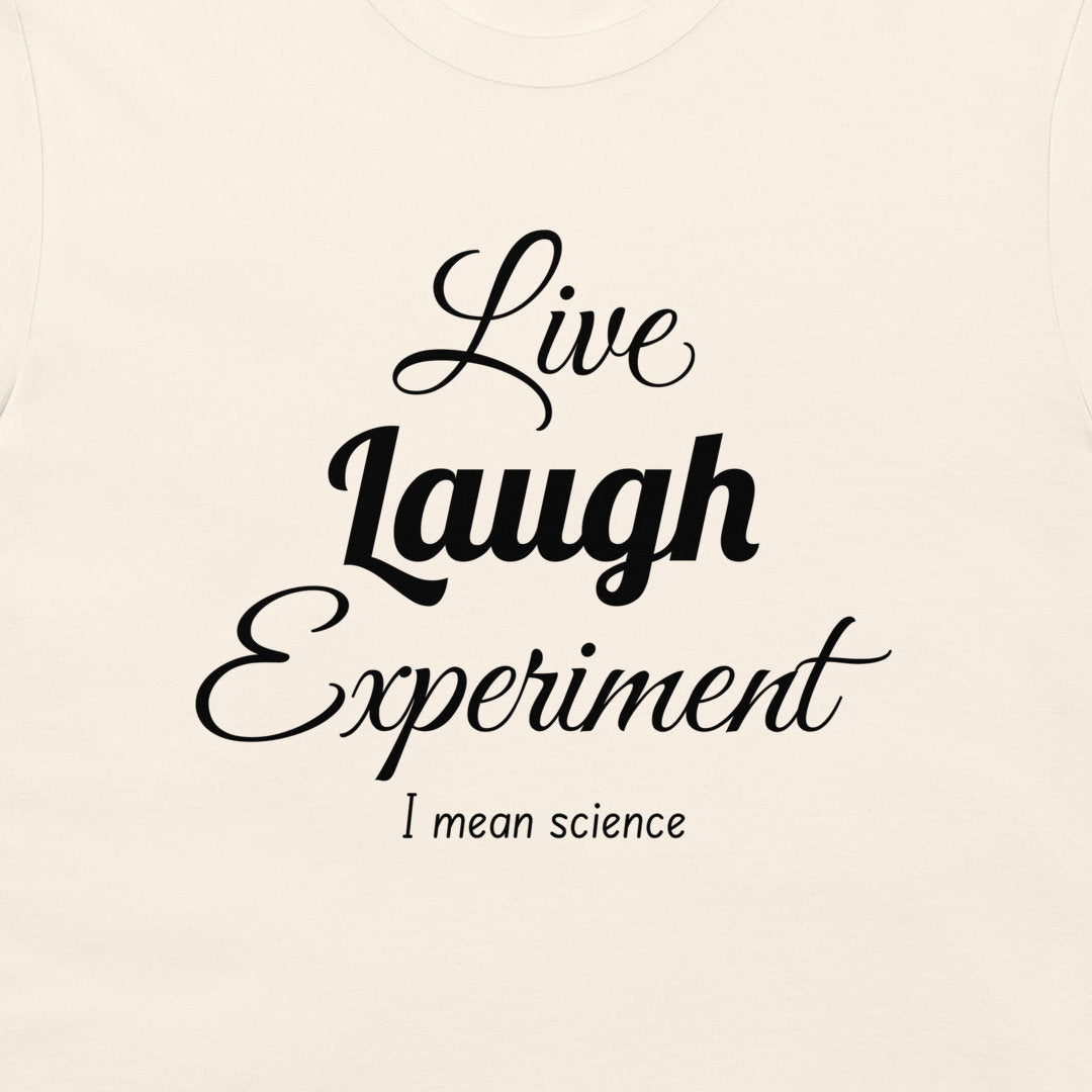A close-up of a light cream-colored t-shirt featuring a black printed graphic that reads 'Live Laugh Experiment I mean science' in stylized fonts.