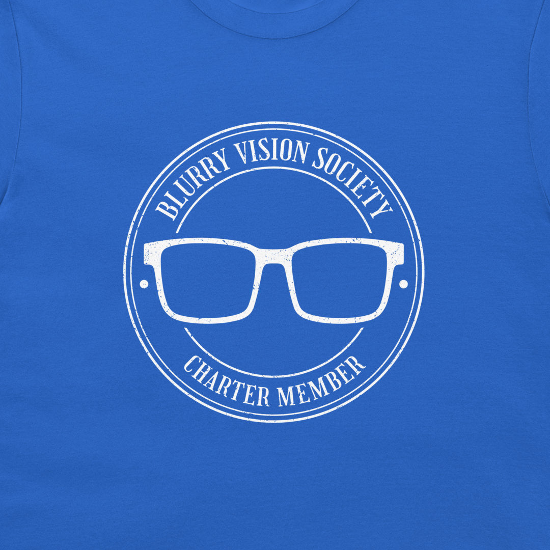 A close-up of a royal blue t-shirt featuring a white distressed graphic of glasses inside a circular seal with the text 'BLURRY VISION SOCIETY' and 'CHARTER MEMBER'.