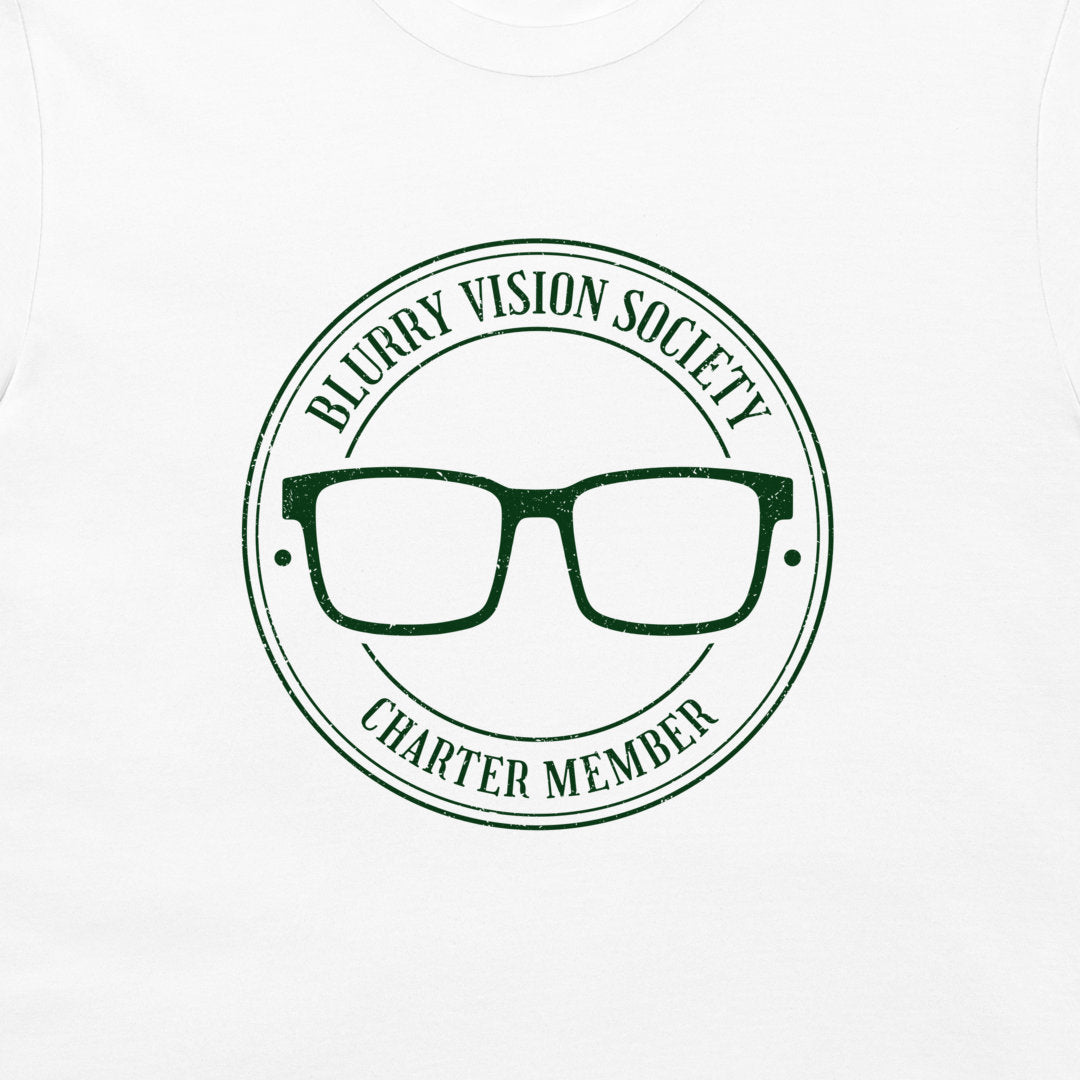 A close-up of a white t-shirt, featuring a dark green circular graphic print that reads 'BLURRY VISION SOCIETY CHARTER MEMBER' around a pair of glasses.