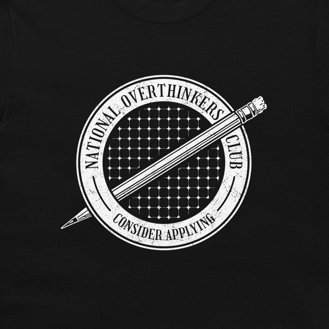 A close-up of a black t-shirt featuring a white circular graphic with a pencil and the text 'NATIONAL OVERTHINKERS CLUB' and 'CONSIDER APPLYING'.
