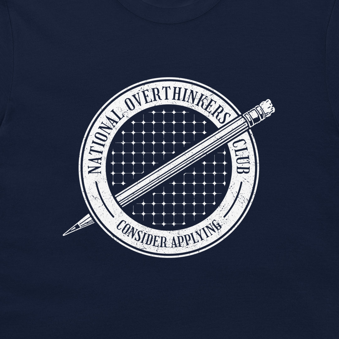 A close-up of a navy blue t-shirt, featuring a white circular graphic print with a pencil and the text 'NATIONAL OVERTHINKERS CLUB' and 'CONSIDER APPLYING'.
