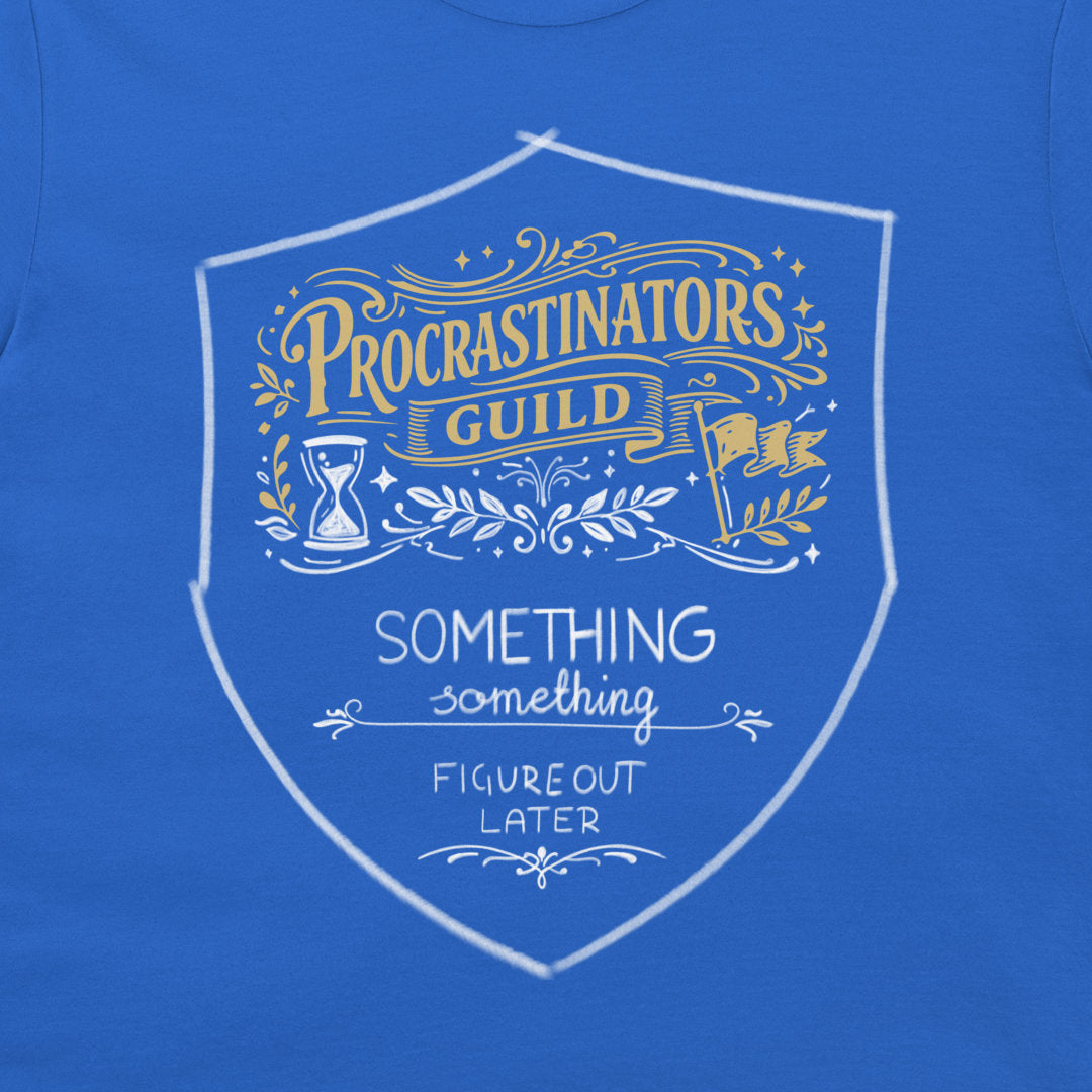 A close-up of a blue t-shirt featuring a white and gold graphic print on the front. The graphic is a shield-shaped emblem with the text 'PROCRASTINATORS GUILD' in gold, 'SOMETHING SOMETHING FIGURE OUT LATER' in white, and decorative illustrations of an hourglass, laurel leaves, and a flag.