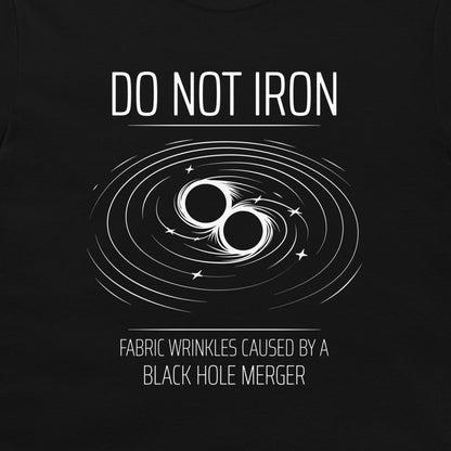 A black graphic print featuring the text 'DO NOT IRON' above a white illustration of two black holes with swirling ring lines, and 'FABRIC WRINKLES CAUSED BY A BLACK HOLE MERGER' below.
