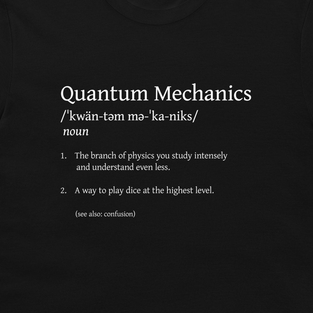 A black t-shirt featuring a white printed graphic that defines 'Quantum Mechanics' in a dictionary style with a humorous second meaning.