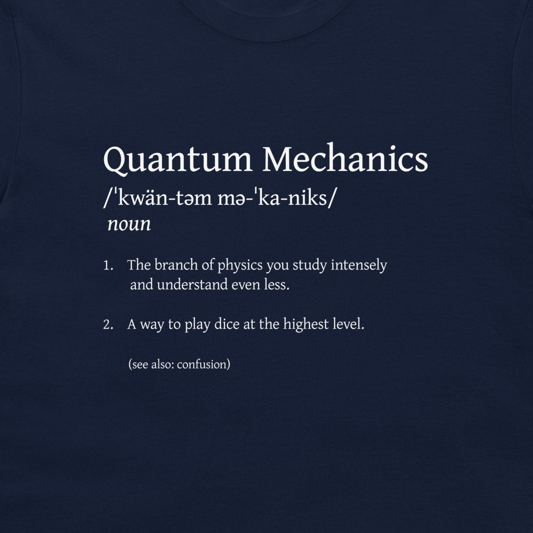 A dark navy blue t-shirt featuring a white printed graphic of the word 'Quantum Mechanics' defined in a dictionary style with humorous, nonsensical dictionary entries.