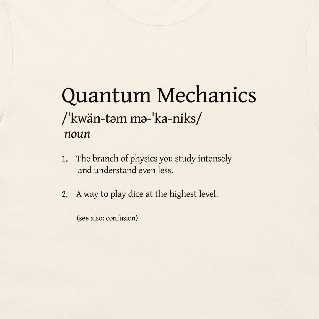 A close-up of a off-white fabric surface with printed black text reading a humorous dictionary-style definition for Quantum Mechanics.