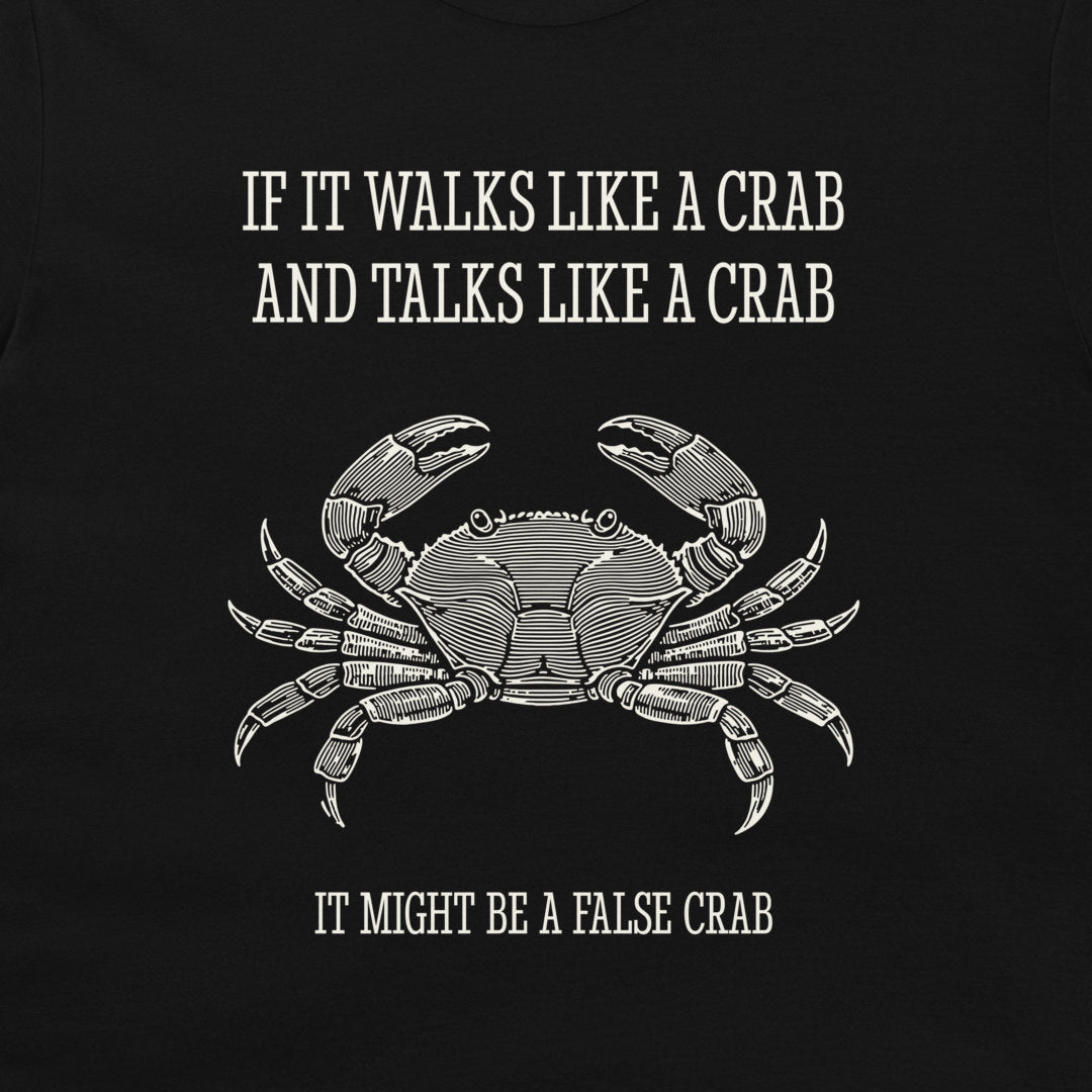 A black graphic t-shirt featuring a white line art illustration of a crab and the humorous text 'IF IT WALKS LIKE A CRAB AND TALKS LIKE A CRAB IT MIGHT BE A FALSE CRAB'.