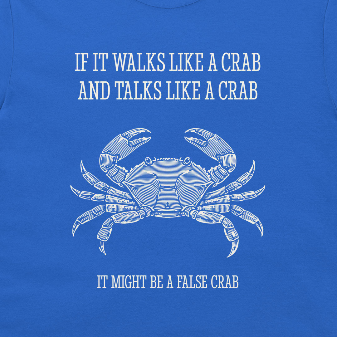 A close-up of a blue graphic t-shirt featuring a white line art illustration of a crab and the humorous text 'IF IT WALKS LIKE A CRAB AND TALKS LIKE A CRAB IT MIGHT BE A FALSE CRAB'.