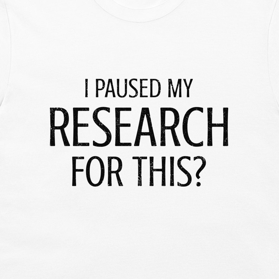 White crewneck t-shirt with black distressed text reading 'I PAUSED MY RESEARCH FOR THIS?' on the front.