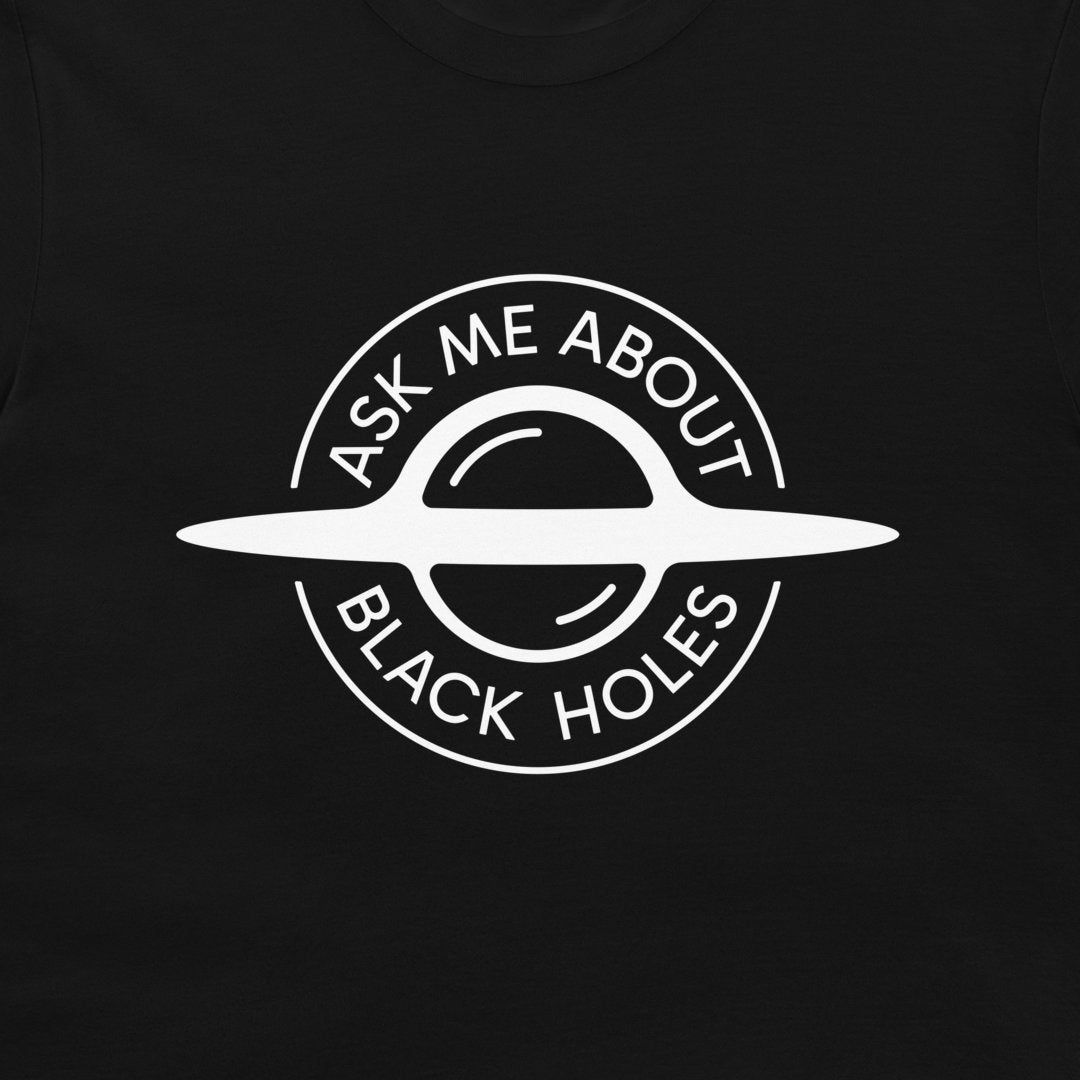 A close-up of a black t-shirt, featuring a white circular graphic of a ringed black hole with the text 'ASK ME ABOUT BLACK HOLES' printed on the chest.