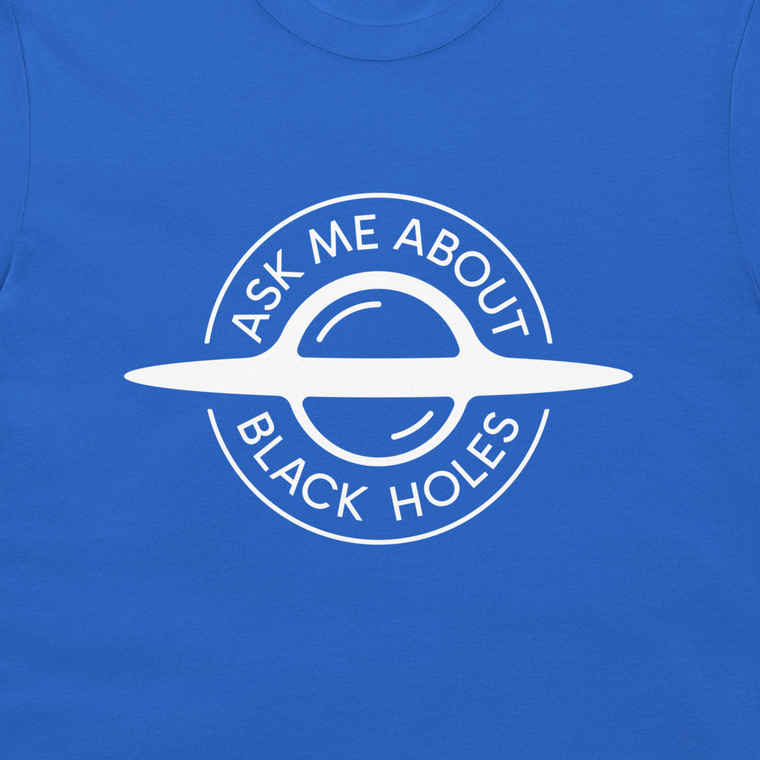 A close-up of a royal blue t-shirt featuring a white circular graphic of a black hole with the text 'ASK ME ABOUT BLACK HOLES' printed in white.