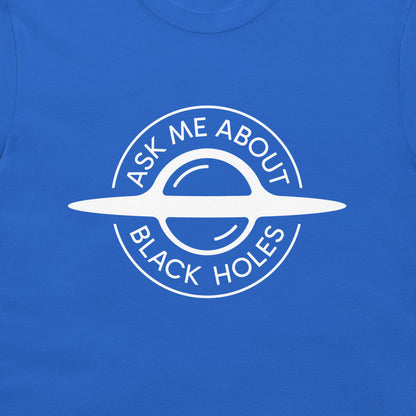 A close-up of a royal blue t-shirt featuring a white circular graphic of a black hole with the text 'ASK ME ABOUT BLACK HOLES' printed in white.