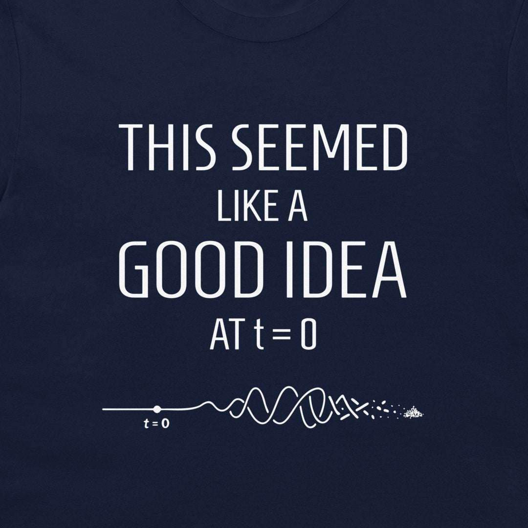 A close-up of a navy blue t-shirt featuring a white graphic print that reads 'THIS SEEMED LIKE A GOOD IDEA AT t=0' above a white timeline illustration with a wave and a small 't=0' label.