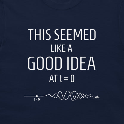 A close-up of a navy blue t-shirt featuring a white graphic print that reads 'THIS SEEMED LIKE A GOOD IDEA AT t=0' above a white timeline illustration with a wave and a small 't=0' label.