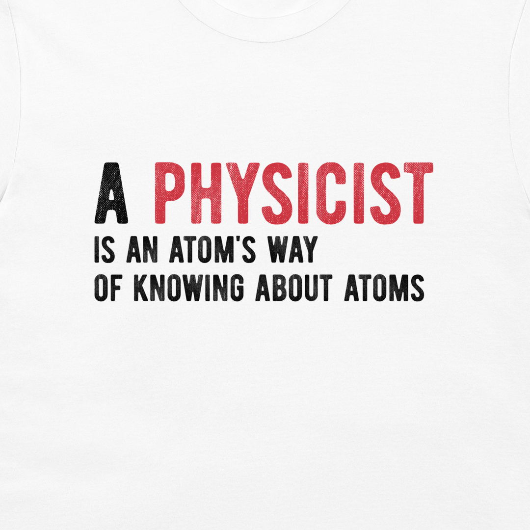 White t-shirt featuring a printed graphic that reads 'A PHYSICIST IS AN ATOM'S WAY OF KNOWING ABOUT ATOMS' in black and red text.