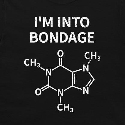 A close-up of a black garment, likely a t-shirt, featuring a white graphic print. The print displays the text 'I'M INTO BONDAGE' above a chemical structure diagram of caffeine.