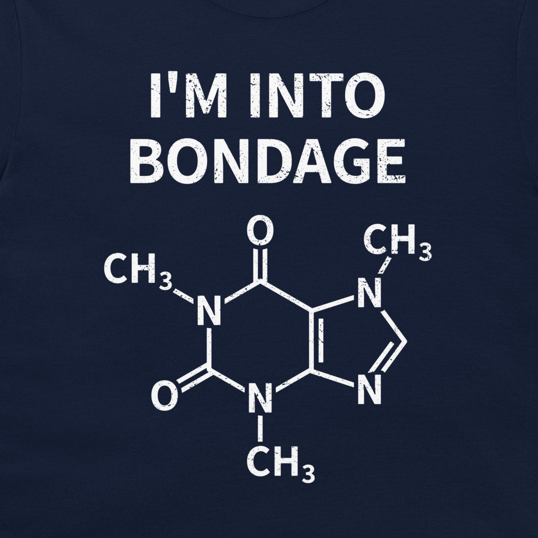 A close-up of a navy blue garment, likely a t-shirt, featuring a white graphic print. The print displays the text 'I'M INTO BONDAGE' above a chemical structure diagram of caffeine.