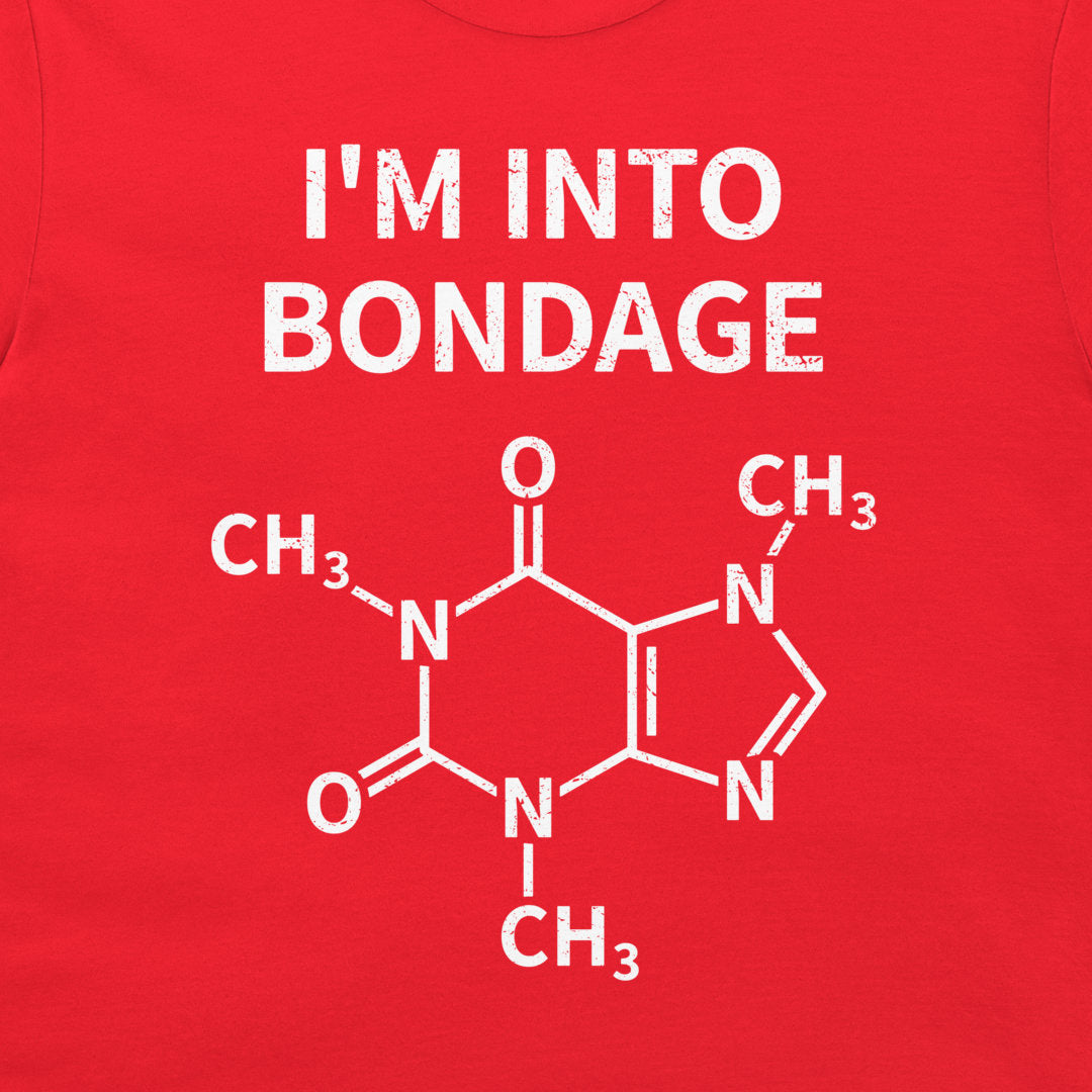 A close-up of a bright red garment, likely a t-shirt, featuring a white graphic print. The print displays the text 'I'M INTO BONDAGE' above a chemical structure diagram of caffeine.