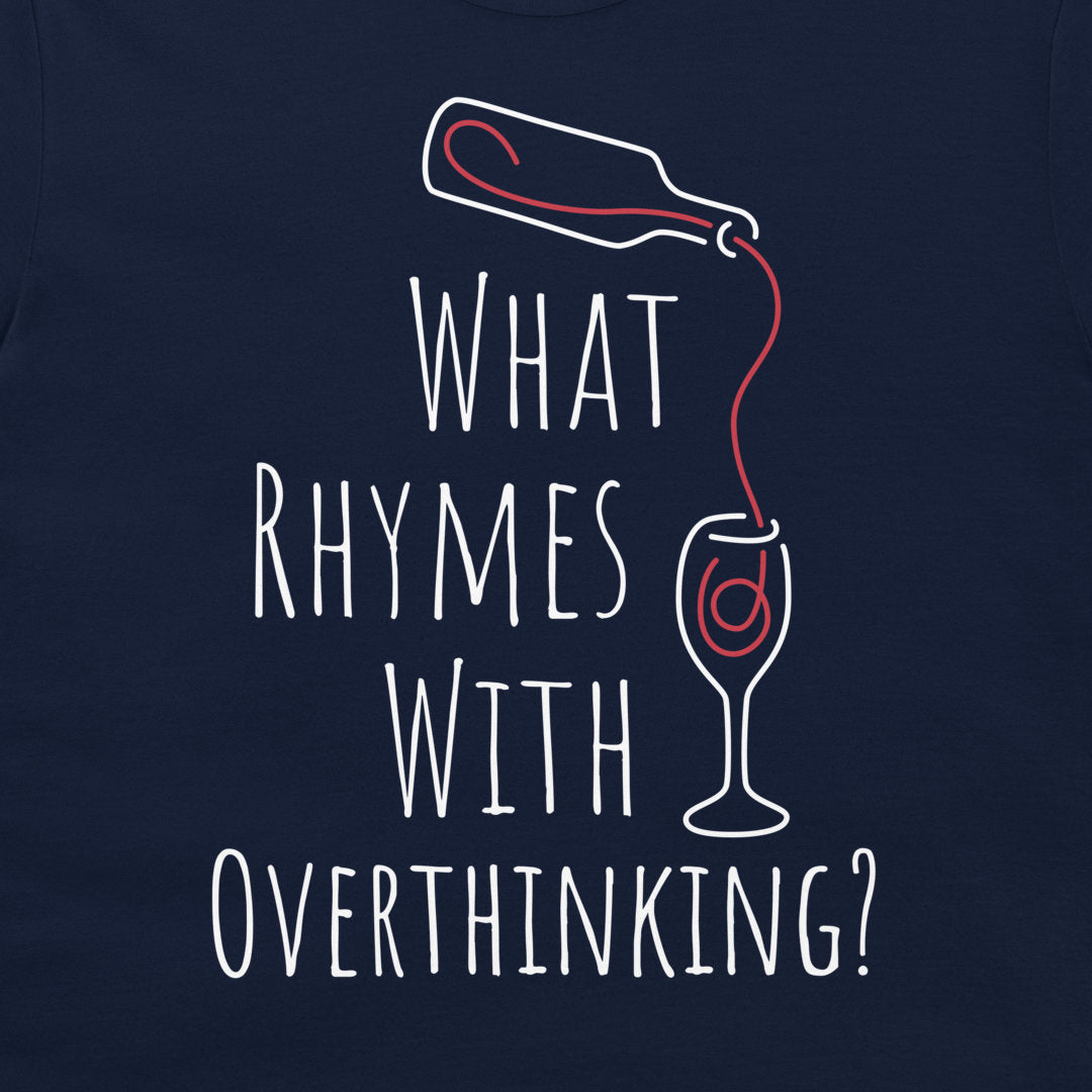 A close-up of a navy blue t-shirt featuring a white and red graphic print that reads 'WHAT RHYMES WITH OVERTHINKING?' accompanied by a line drawing of a bottle pouring red liquid into a wine glass.