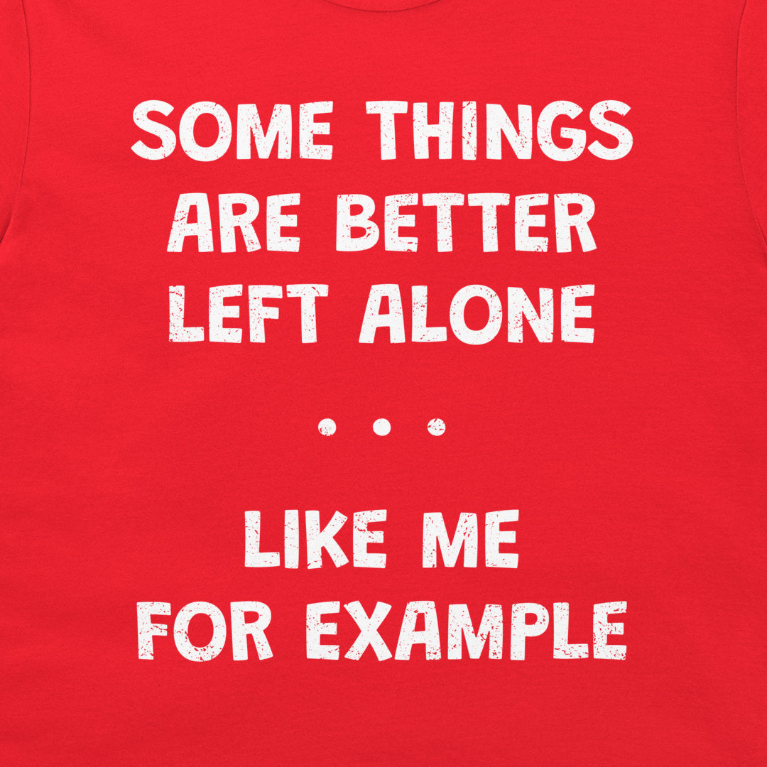 A close-up of a bright red garment, likely a t-shirt, featuring a distressed white typographic print that reads 'SOME THINGS ARE BETTER LEFT ALONE. LIKE ME FOR EXAMPLE'.