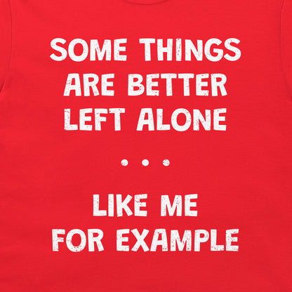 A close-up of a bright red garment, likely a t-shirt, featuring a distressed white typographic print that reads 'SOME THINGS ARE BETTER LEFT ALONE. LIKE ME FOR EXAMPLE'.