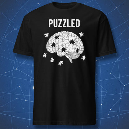 white puzzle brain t-shirt design with scattered pieces and “Puzzled” text on black shirt