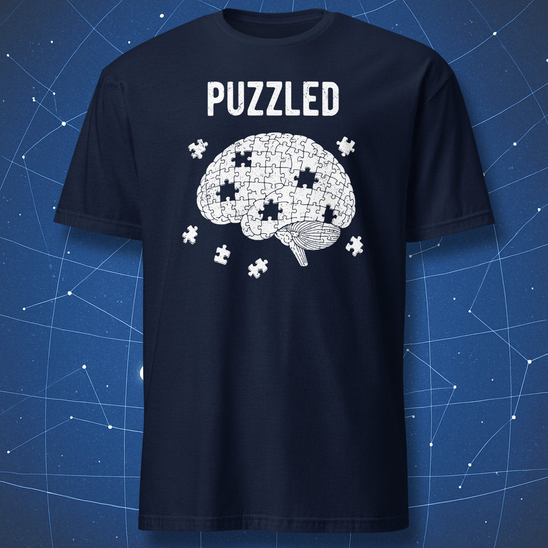 white brain puzzle graphic with missing pieces and “Puzzled” text on navy blue shirt