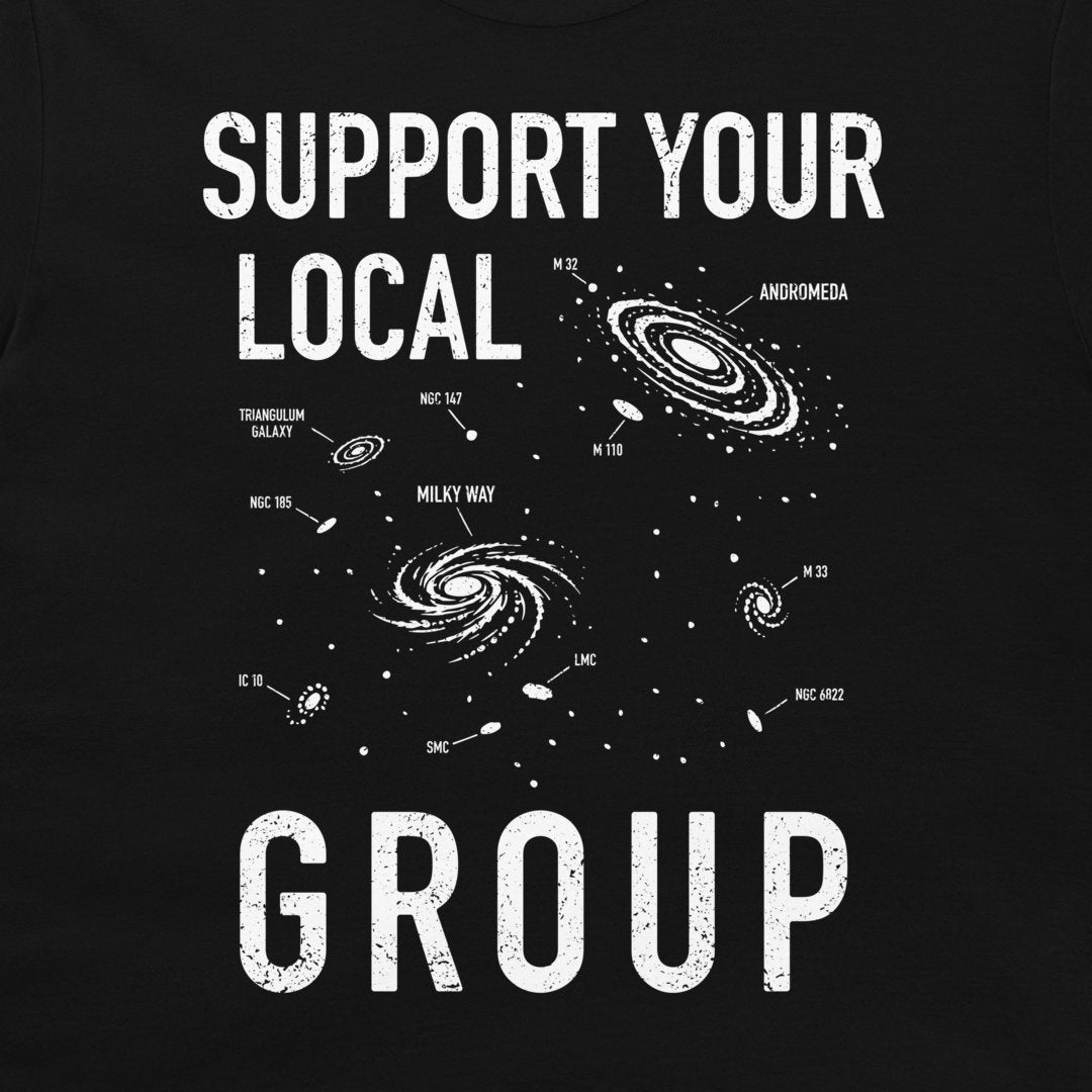 A black graphic t-shirt featuring a white distressed print that reads 'SUPPORT YOUR LOCAL GROUP' with various labeled galaxies, including Andromeda, Milky Way, and Triangulum.