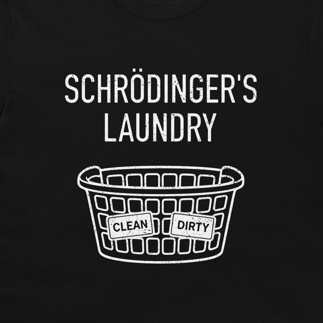 A close-up of a black t-shirt, featuring a white distressed graphic that reads 'SCHRÖDINGER'S LAUNDRY' above a laundry basket with labels reading 'CLEAN' and 'DIRTY'.