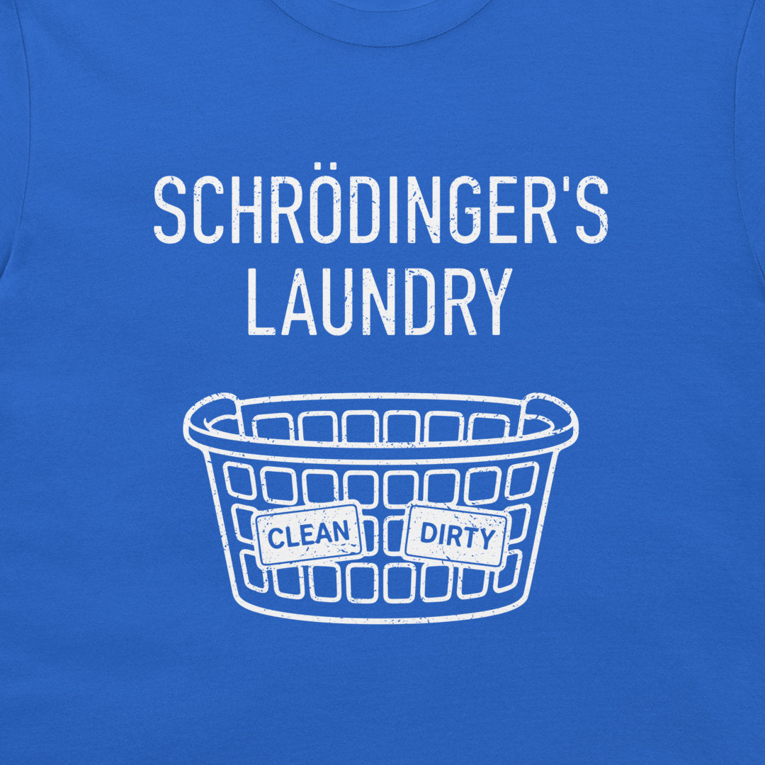 A close-up of a blue T-shirt with a white graphic print that reads 'SCHRÖDINGER'S LAUNDRY' above a laundry basket illustration with labels reading 'CLEAN' and 'DIRTY'.