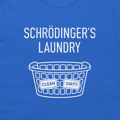 A close-up of a blue T-shirt with a white graphic print that reads 'SCHRÖDINGER'S LAUNDRY' above a laundry basket illustration with labels reading 'CLEAN' and 'DIRTY'.