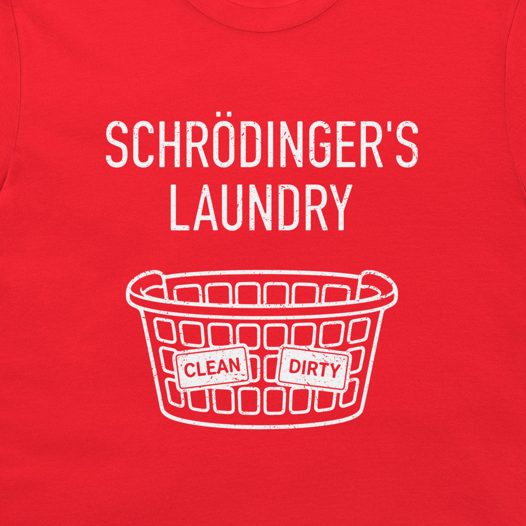 A close-up of a bright red t-shirt, featuring a white graphic print that reads 'SCHRÖDINGER'S LAUNDRY' above a white laundry basket illustration with 'CLEAN' and 'DIRTY' labels.