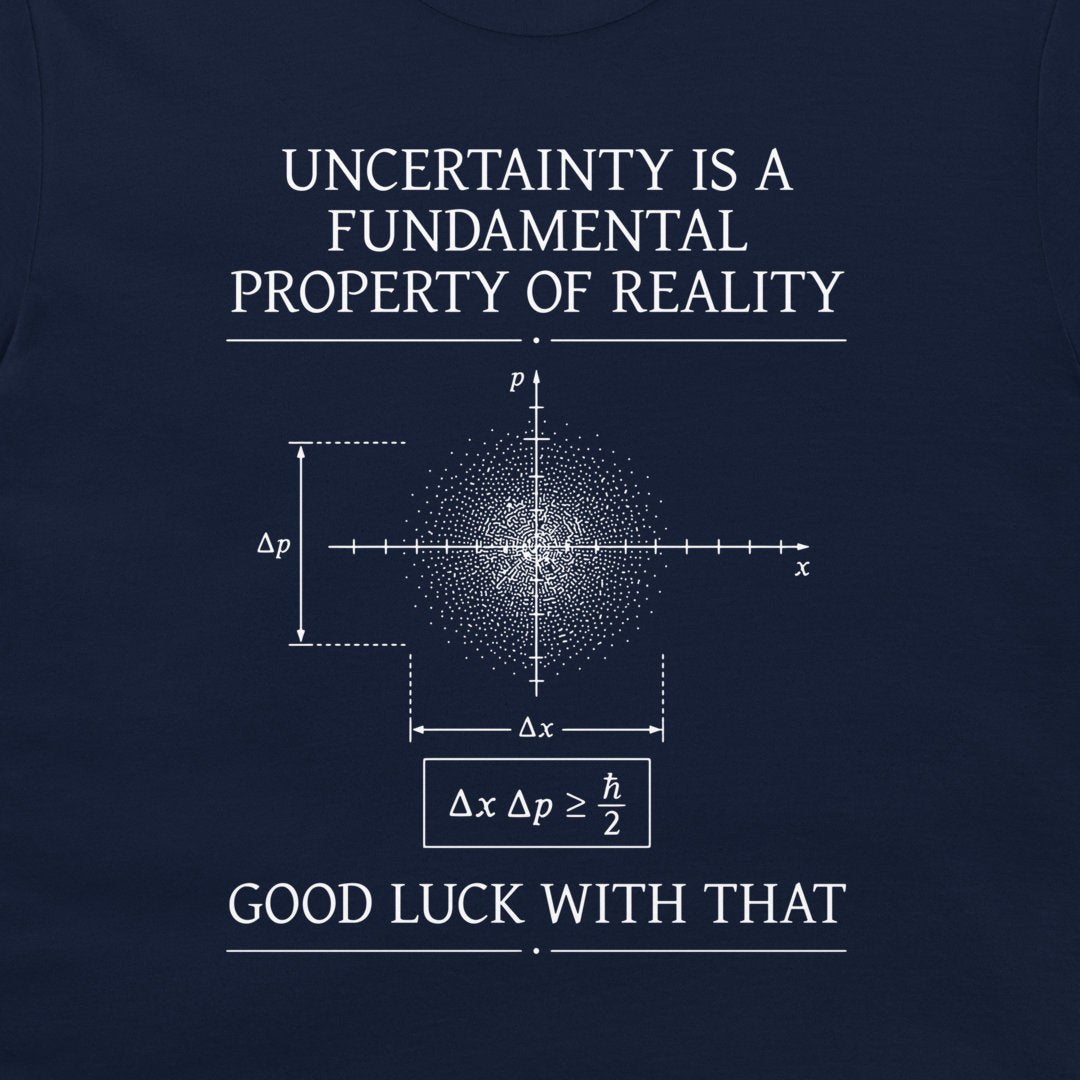 A dark navy blue graphic print on a t-shirt featuring white text and a quantum mechanics uncertainty principle diagram. The text reads 'UNCERTAINTY IS A FUNDAMENTAL PROPERTY OF REALITY' and 'GOOD LUCK WITH THAT'.