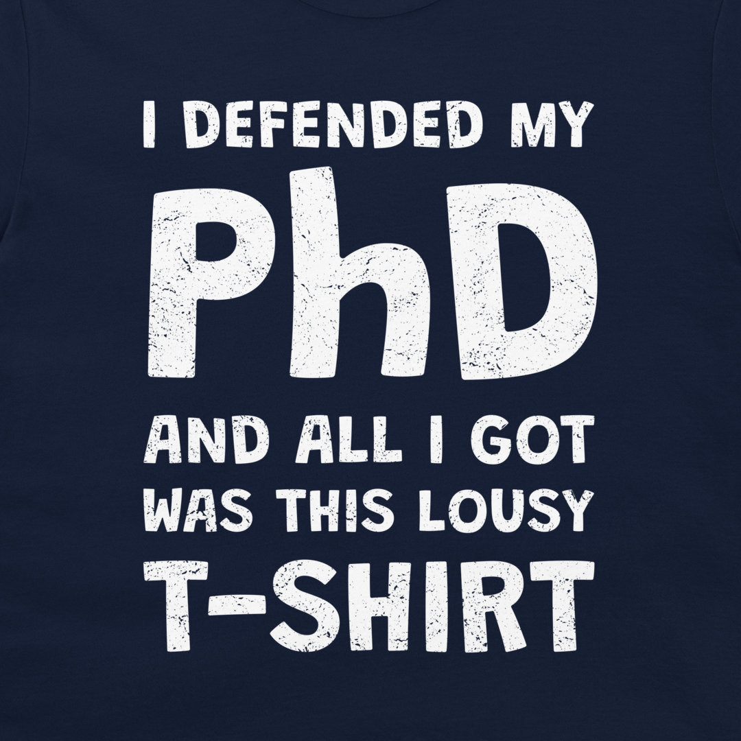 A close-up of a navy blue T-shirt with a distressed white graphic print that reads, 'I DEFENDED MY PhD AND ALL I GOT WAS THIS LOUSY T-SHIRT'.