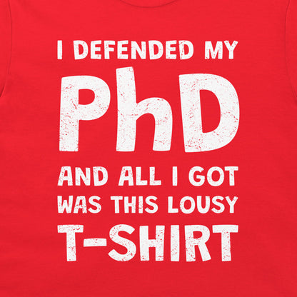 A close-up of a bright red T-shirt with a distressed white graphic text that reads, 'I DEFENDED MY PhD AND ALL I GOT WAS THIS LOUSY T-SHIRT'.