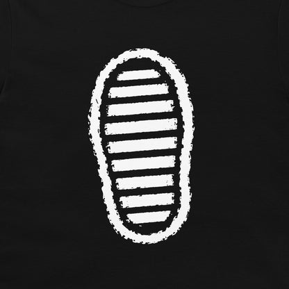 A close-up of a black t-shirt, featuring a white distressed graphic of a shoe sole with horizontal stripes.