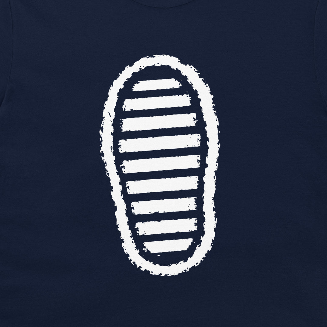 A close-up of a navy blue t-shirt, featuring a white graphic print of a shoe sole with horizontal stripes.
